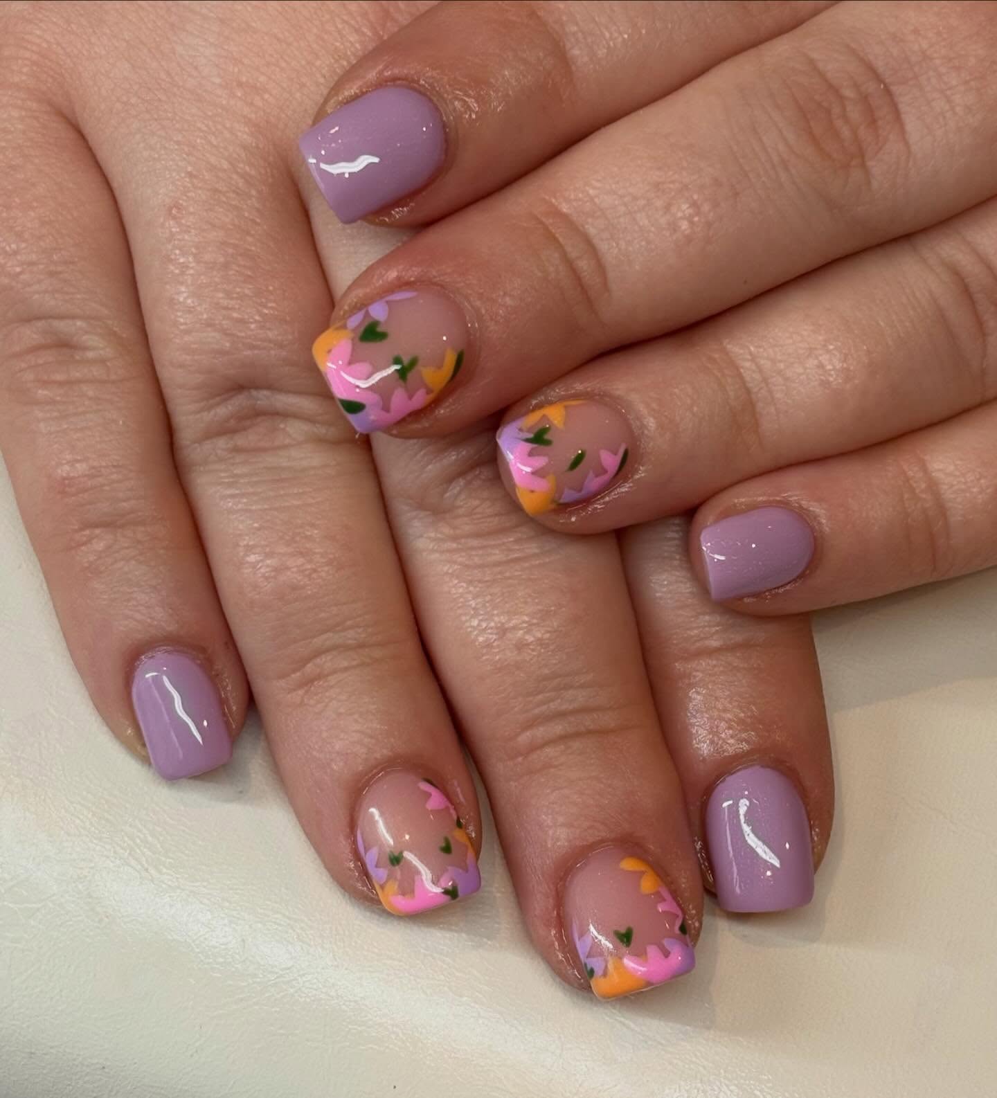 Soft lilac nails with playful floral accents for the sweetest spring vibe